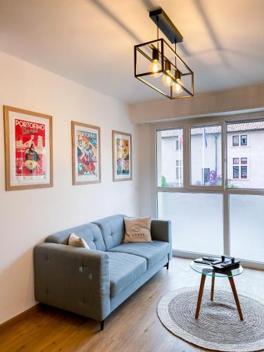 un salon avec un canapé bleu et une table dans l'établissement Le Pagnol - Hyper centre - Clim, à Cassis