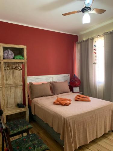 a bedroom with a bed with red walls and a ceiling at Suíte elegante Caxambu in Caxambu