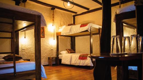 a room with two bunk beds and a table at Hostal Restaurant La Cigale in Cuenca