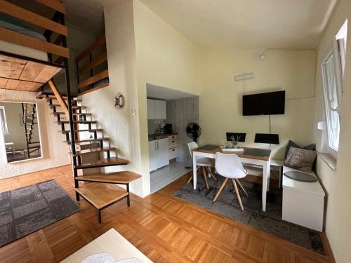 ein Wohnzimmer mit einem Esstisch und einer Küche in der Unterkunft Prizna Apartments in Prizna