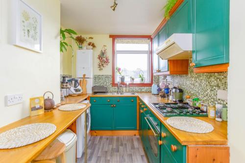 a kitchen with blue cabinets and a counter top at Bright & Spacious Double Room with Garden View- Close to Airport & City Centre in Edinburgh