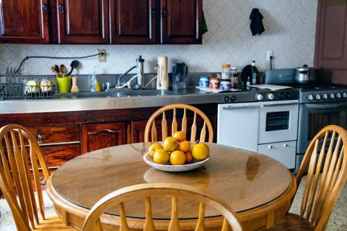 una cocina con una mesa de madera y un bol de fruta. en Margaritas Eco Haus en Querétaro