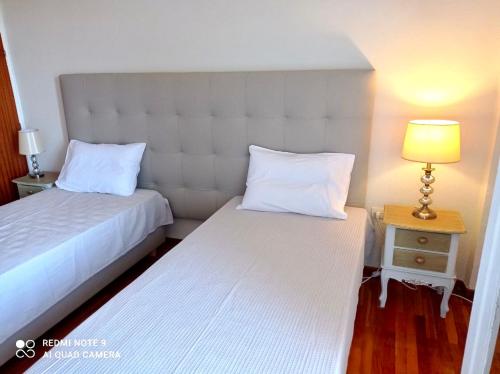 sypialnia z 2 łóżkami i stolikiem nocnym z lampką w obiekcie Sunshine Apartment w Prewezie