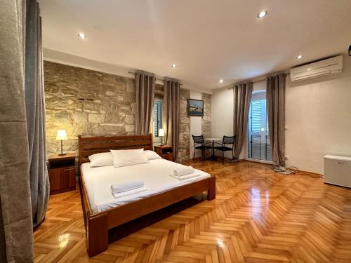 a bedroom with a bed and a stone wall at Villa Dante with swimming pool in Trogir