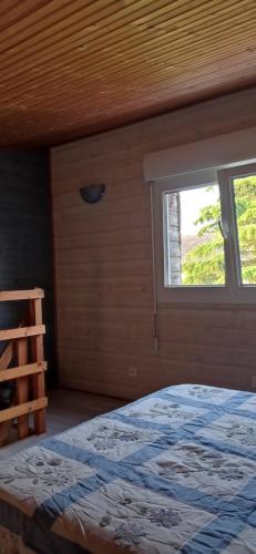1 dormitorio con cama y ventana en La chatière en Pontaubault