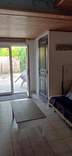 une chambre avec un lit et une porte coulissante en verre dans l'établissement La chatière, à Pontaubault