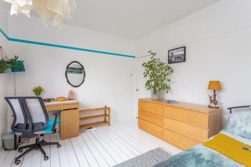 um quarto com uma cama, uma secretária e uma cadeira em Nordic style room in a quiet residential area em Edimburgo