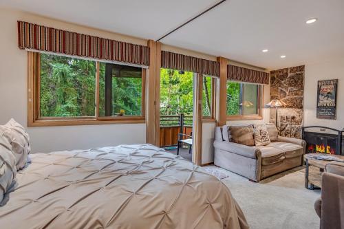 a bedroom with a bed and a couch and windows at Laurelwood Condominiums 307 in Snowmass Village