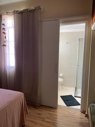 1 dormitorio con 1 cama y baño con ducha en Suíte elegante Caxambu, en Caxambu