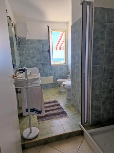 a bathroom with a sink and a toilet and a window at La Terrazza di Elisa in Marina di San Lorenzo