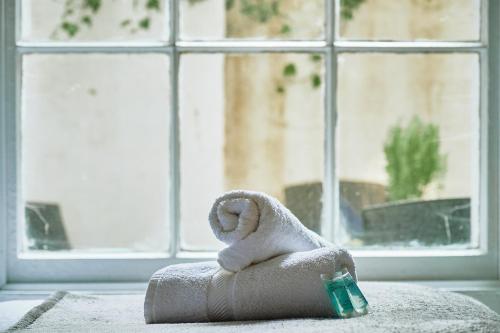 a towel animal sitting on a pillow in front of a window at Stylish 2 BR in Clifton - Garden in Bristol