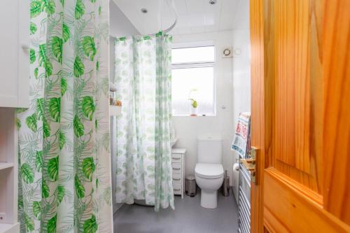 a bathroom with a toilet and a shower curtain at Nordic style room in a quiet residential area in Edinburgh