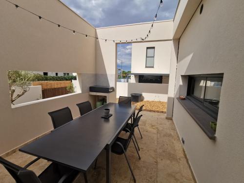 une salle à manger avec une table et des chaises noires dans l'établissement Villa 4* Bella ciao, entre mer, lac et montagnes, à Villeneuve-de-la-Raho