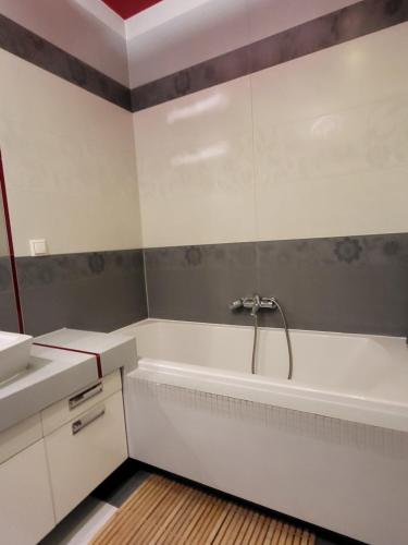 La salle de bains blanche est pourvue d'une baignoire et d'un lavabo. dans l'établissement PokornaM1, à Varsovie