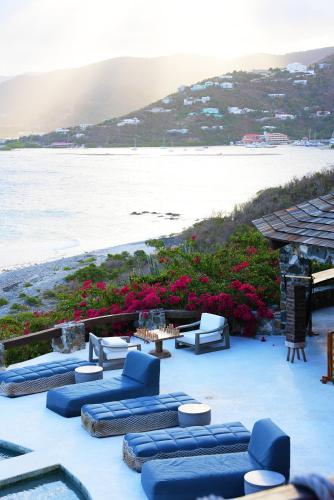 a patio with blue couches and a view of the ocean at The Aerial, BVI in Tortola Island