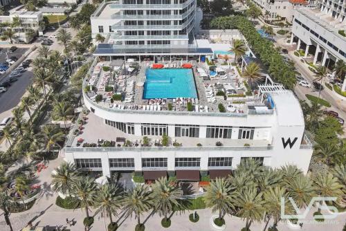 an aerial view of a building with a swimming pool at W Hotel Ftl Beach Oceanview 2Bed 2Bath Condo Resort in Fort Lauderdale