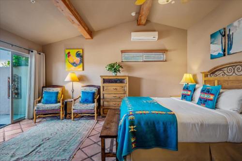 1 dormitorio con 1 cama y 2 sillas en Adobe Hacienda, en Sedona