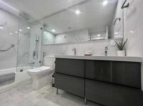 a bathroom with a sink and a toilet and a shower at Ocean Reserve Condo by FlatsAway in Miami Beach