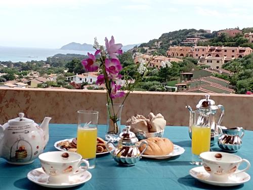 een tafel met een blauwe tafeldoek met thee en koffie bij Villa Milena Costa Rei VISTA MARE in Costa Rei