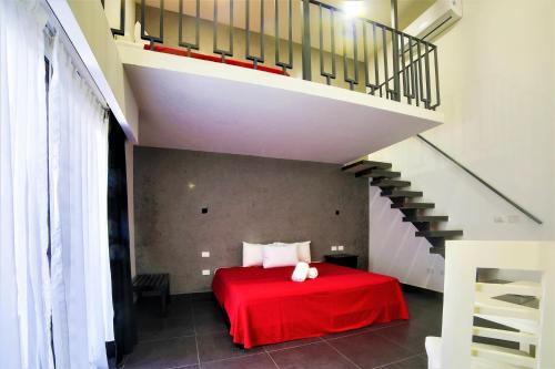 a bedroom with a red bed and a staircase at Hotel Colonial Playa del Carmen in Playa del Carmen