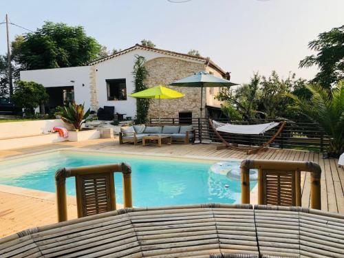 une piscine avec des chaises et un hamac, ainsi qu'une maison dans l'établissement Magnifique villa Antibes, à Antibes