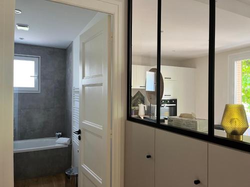 La salle de bains est pourvue d'un miroir et d'une baignoire. dans l'établissement Bel appartement familial - T4 proche du lac, à Annecy