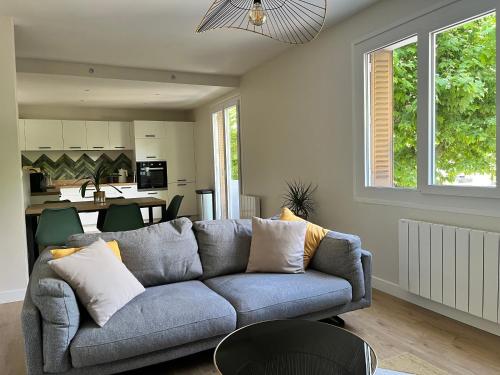 un salon avec un canapé bleu et une cuisine dans l'établissement Bel appartement familial - T4 proche du lac, à Annecy