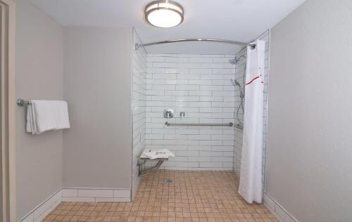 a bathroom with a shower with a shower curtain at Red Roof PLUS Miami Airport in Miami