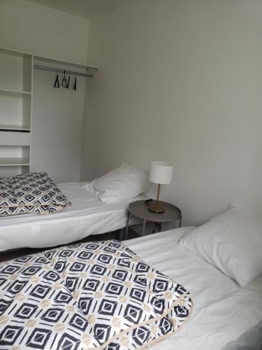twee bedden naast elkaar in een slaapkamer bij LA POINTE DE SEL in Fouesnant