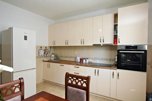 kuchnia z białymi szafkami i kuchenką mikrofalową w obiekcie Petra flat apartment w Barze