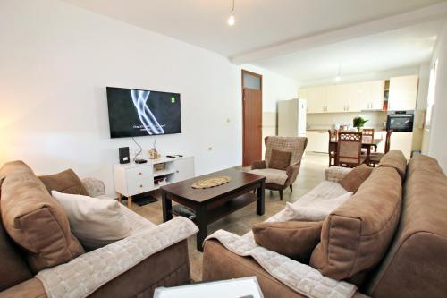 een woonkamer met 2 banken en een tv bij Petra flat apartment in Bar