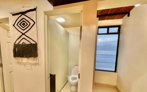 a bathroom with a toilet and a large window at Lovely Beach 1-Bed unit in Playas de Tijuana in Tijuana