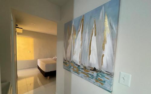 a bedroom with a bed and a painting on the wall at Lovely Beach 1-Bed unit in Playas de Tijuana in Tijuana