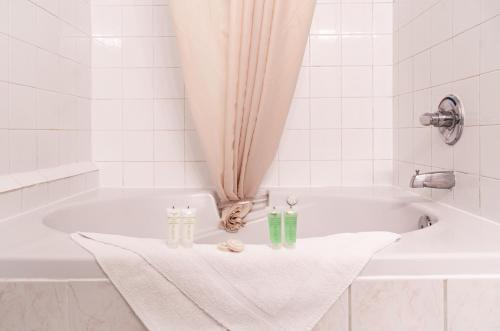 a white bath tub with a towel and two candles at Mountain View Inn in Canmore