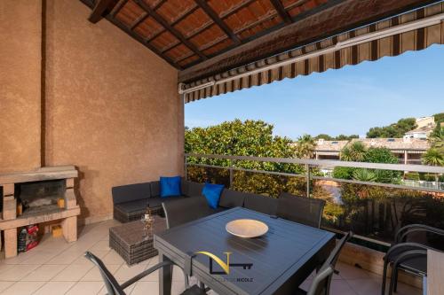 a patio with a table and chairs on a balcony at Cozy duplexterrace barbecue pool beach on foot in Le Pradet