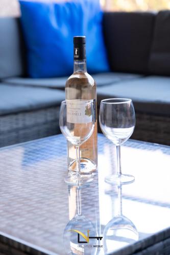 une bouteille de vin et deux verres à vin sur une table dans l'établissement Cozy duplexterrace barbecue pool beach on foot, au Pradet