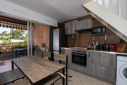 a kitchen with a wooden table and a dining room at Cozy duplexterrace barbecue pool beach on foot in Le Pradet