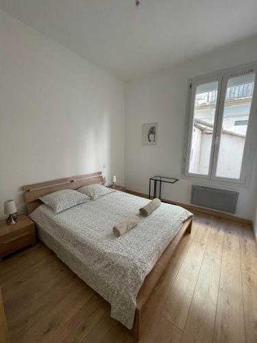 une chambre avec un lit avec deux serviettes dessus dans l'établissement Cosy nid douillet au cœur du centre ville de Perpignan, à Perpignan