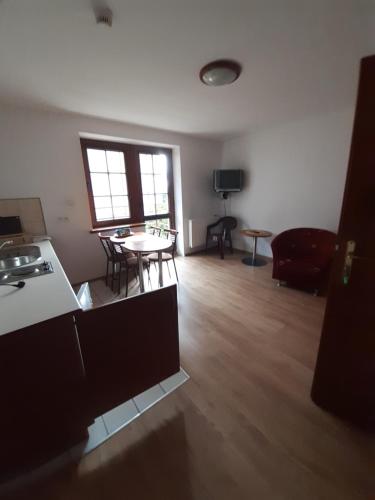 an empty living room with a table and a kitchen at Willa Julia in Karwia