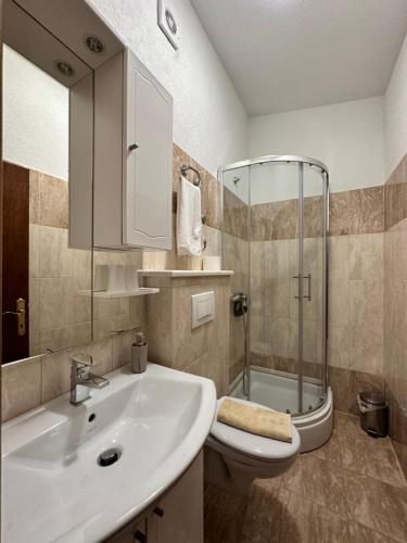 a bathroom with a sink and a shower and a toilet at Villa Dante in Trogir