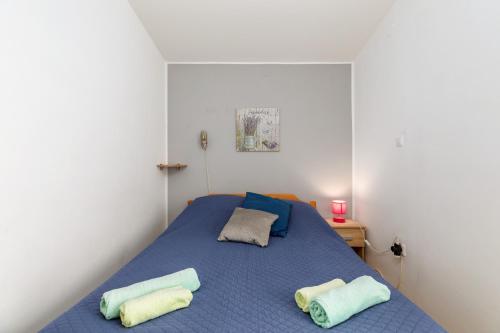 - une chambre avec un lit bleu et 2 serviettes dans l'établissement Apartments Lora, à Pula