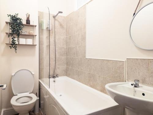 a bathroom with a tub and a toilet and a sink at Guest Rooms In Anfiled Near Stadium, Free Parking in Liverpool