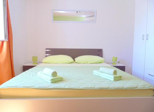 a bedroom with a bed with two towels on it at Guest House Petricevic in Split