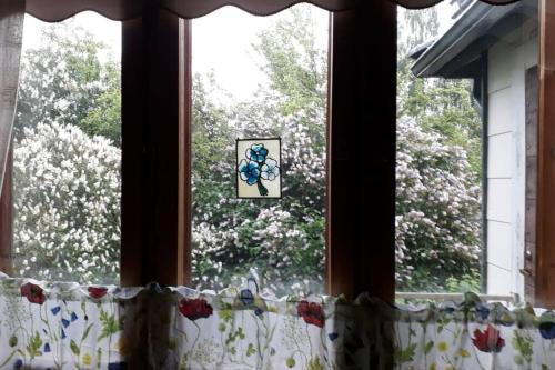 ein Fenster mit einem Vorhang mit einem Bild von Blumen in der Unterkunft Villa Vintage in Tammela