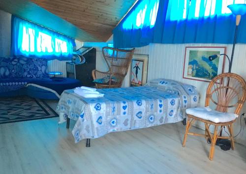 ein Schlafzimmer mit einem Bett und einem Stuhl sowie blauen Lichtern in der Unterkunft Mansarda seaview in Senigallia