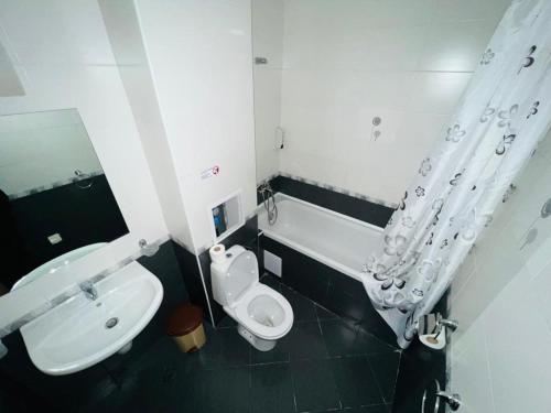uma casa de banho com um WC branco e um lavatório. em PSB Apartments in Gardens of Eden em Sveti Vlas