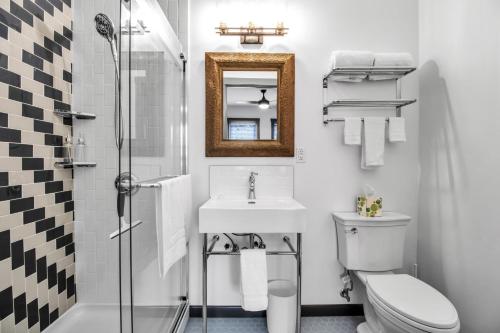 ein Badezimmer mit einem Waschbecken, einem WC und einem Spiegel in der Unterkunft Webber Hotel in Lyndonville