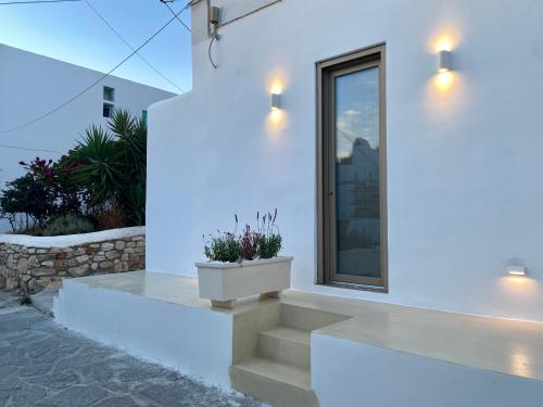a white house with stairs and a window at Asteras Cozy Stay in Naousa
