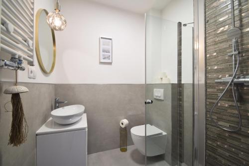 een badkamer met een toilet, een wastafel en een douche bij Apartamenty Ada 2 Resort Klifowa Rewal in Rewal
