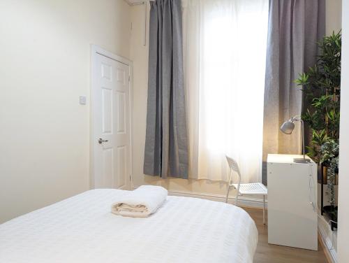 a bedroom with a white bed and a window at Guest Rooms In Anfiled Near Stadium, Free Parking in Liverpool